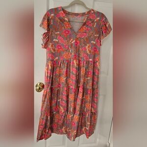 Dress features a v-neck, flutter sleeves, and a flowy midi length with pockets